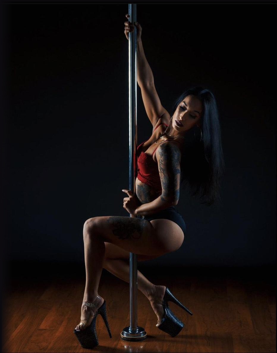Pole dancer in heels posing on the pole
